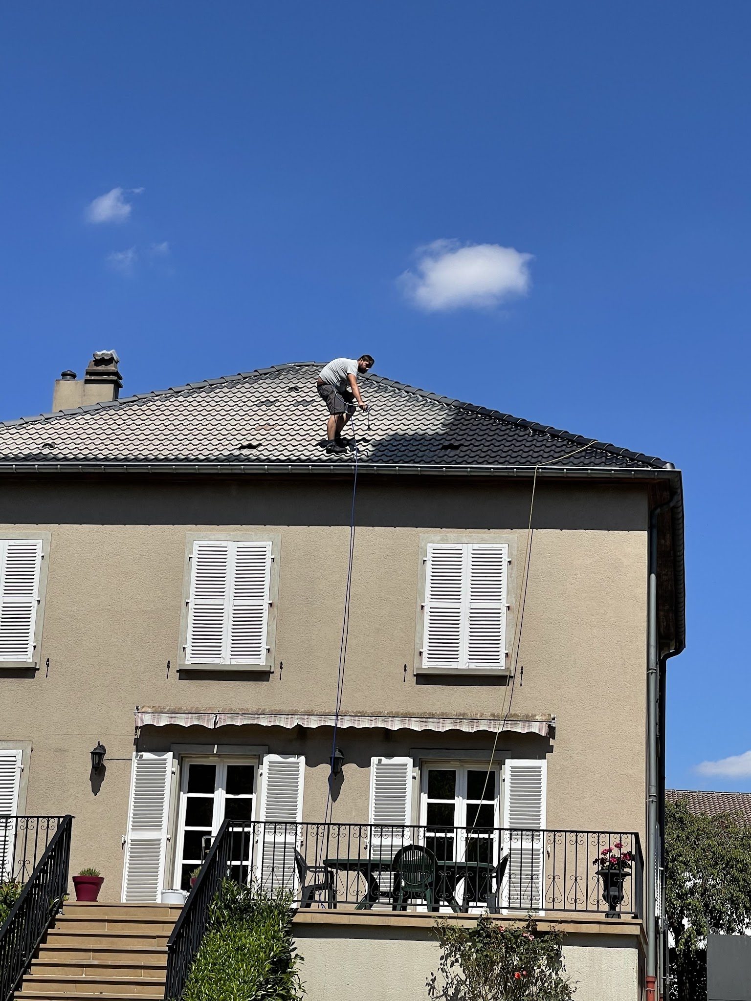 Un couvreur de François Père et Fils traite la toiture d'une maison de maître